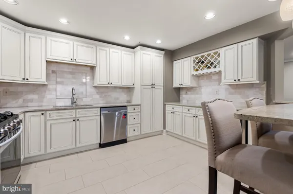 a kitchen with stainless steel appliances granite countertop a white cabinets sink and a stove