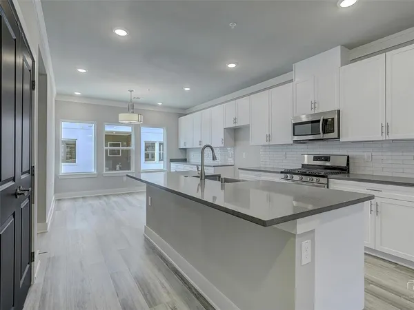 a kitchen with stainless steel appliances granite countertop a sink stove and refrigerator