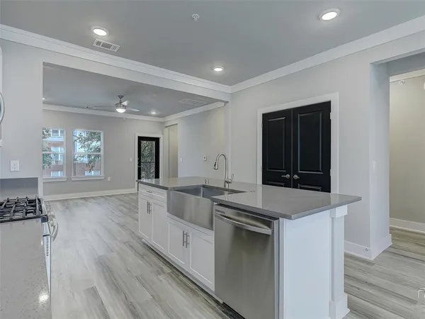 a large kitchen with stainless steel appliances granite countertop a lot of counter space and wooden floor