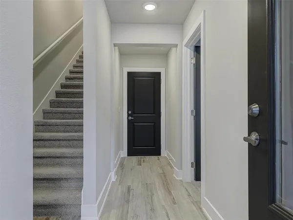 a view of a hallway with wooden floor and entryway
