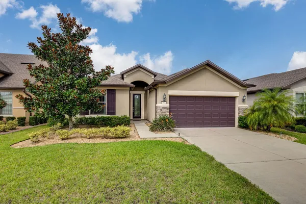 a front view of a house with a garden and yard