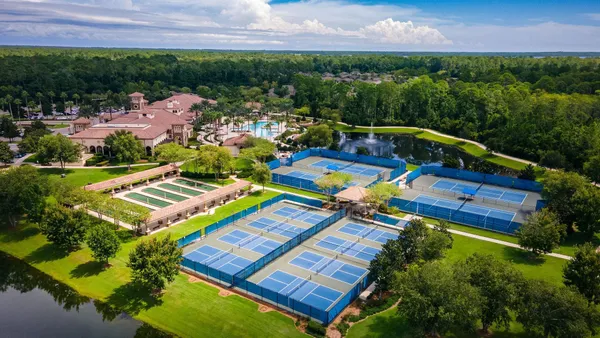 a view of a swimming pool with lawn chairs and plants
