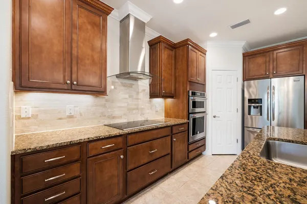 a kitchen with stainless steel appliances granite countertop a refrigerator and a sink