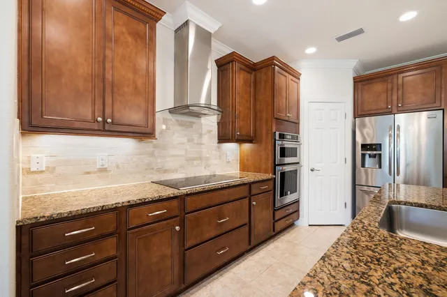 a kitchen with stainless steel appliances granite countertop a refrigerator and a sink