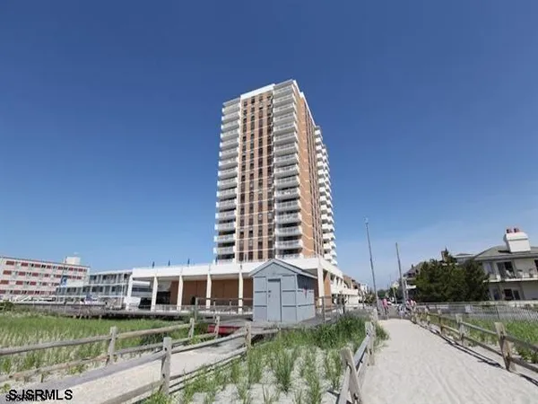 a view of a large building with a yard and a wooden fence