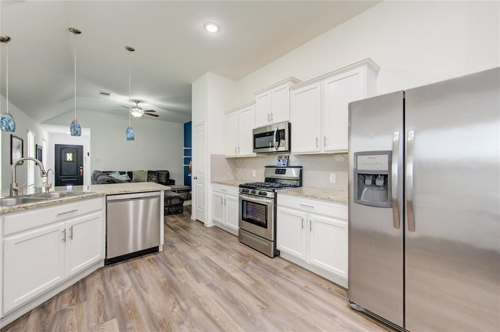 25519 Pitchfork Ranch Place Katy, TX 77493 - Photo 13 of 31 a kitchen with a refrigerator stove and sink