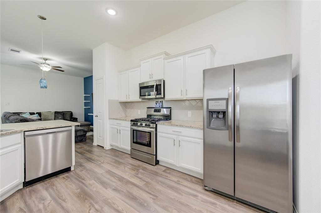 25519 Pitchfork Ranch Place Katy, TX 77493 - Photo 14 of 31 a kitchen with a refrigerator stove and sink