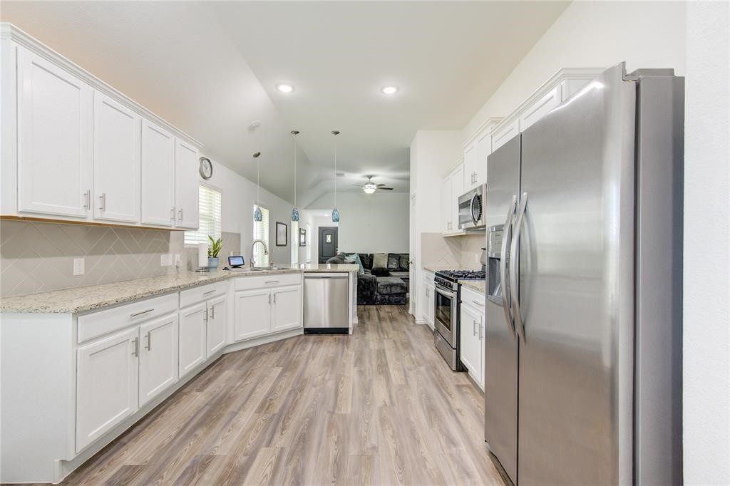 25519 Pitchfork Ranch Place Katy, TX 77493 - Photo 15 of 31 a large kitchen with a center island wooden floor stainless steel appliances and cabinets