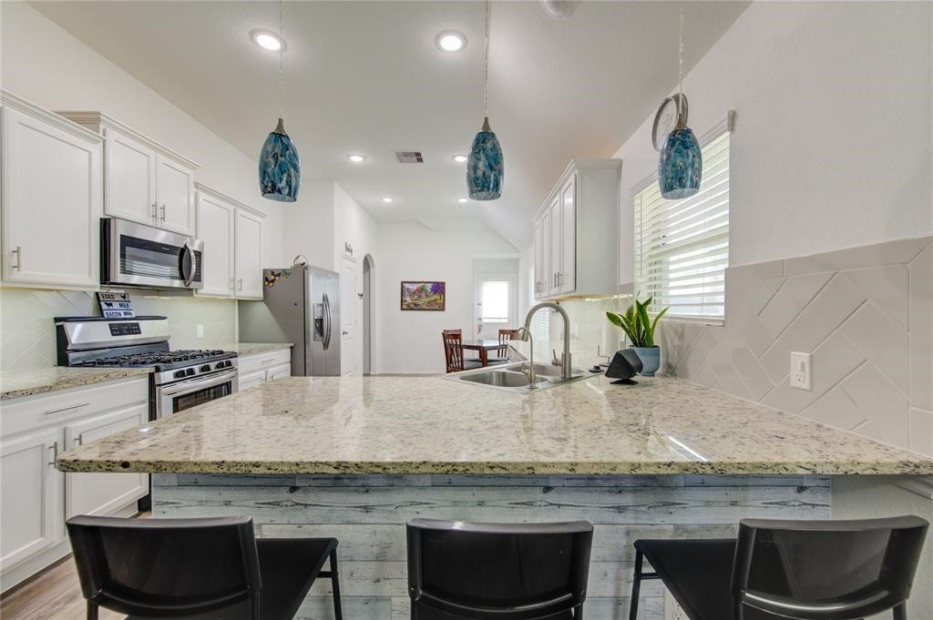 25519 Pitchfork Ranch Place Katy, TX 77493 - Photo 17 of 31 a kitchen with granite countertop a sink a counter top space appliances and cabinets