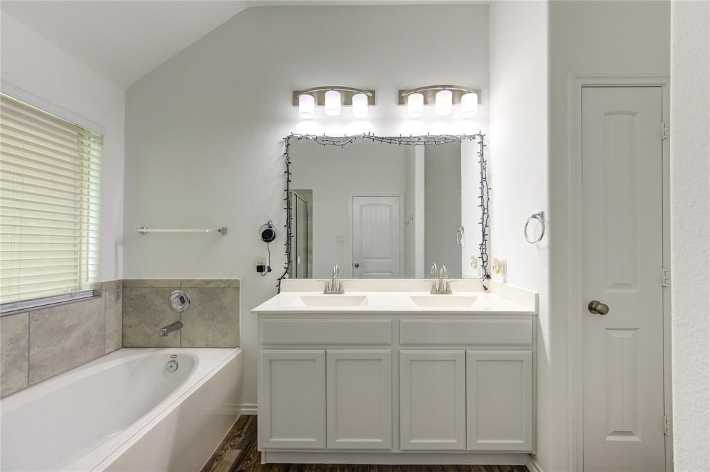 25519 Pitchfork Ranch Place Katy, TX 77493 - Photo 19 of 31 a bathroom with a sink double vanity mirror and bathtub
