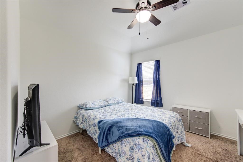25519 Pitchfork Ranch Place Katy, TX 77493 - Photo 21 of 31 a bedroom with a bed and a chandelier