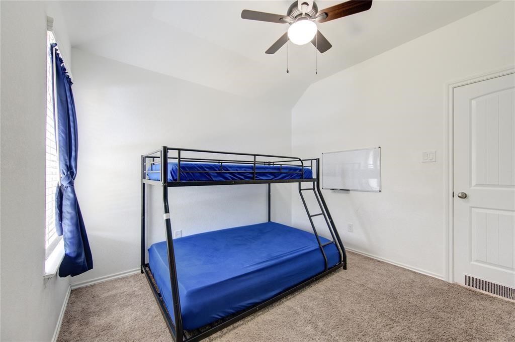 25519 Pitchfork Ranch Place Katy, TX 77493 - Photo 23 of 31 a bedroom with a bed and a chandelier