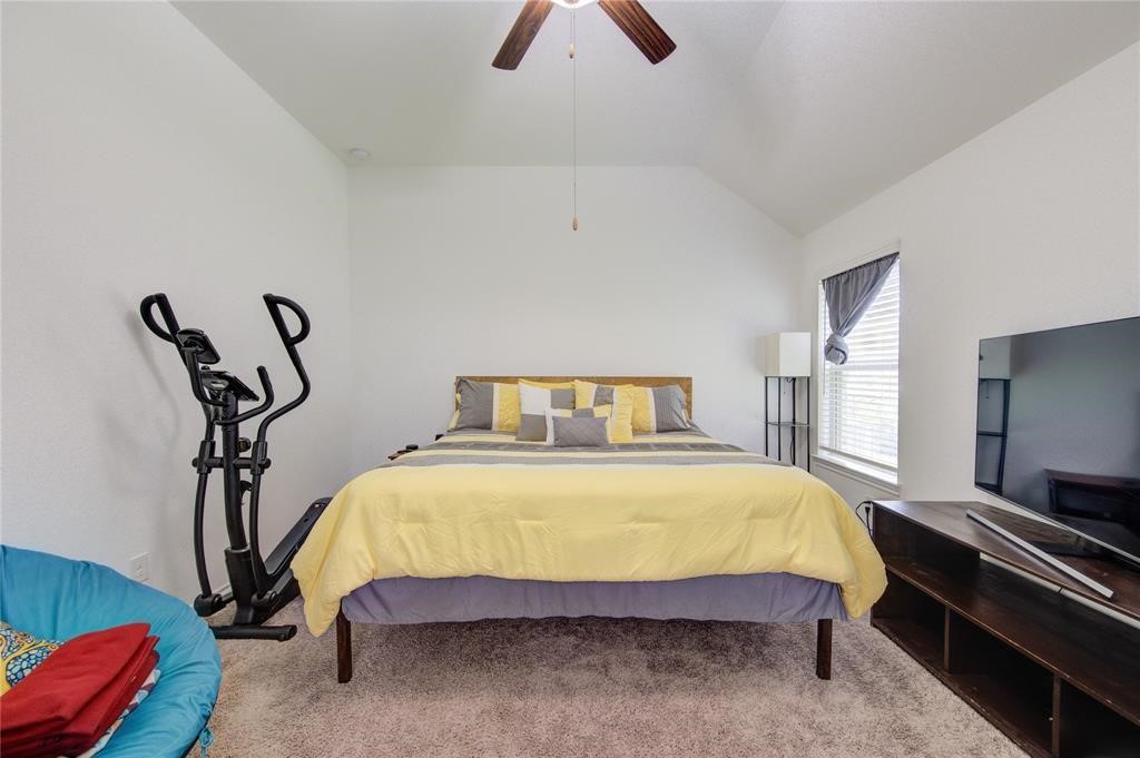 25519 Pitchfork Ranch Place Katy, TX 77493 - Photo 28 of 31 a bedroom with a bed and a chandelier