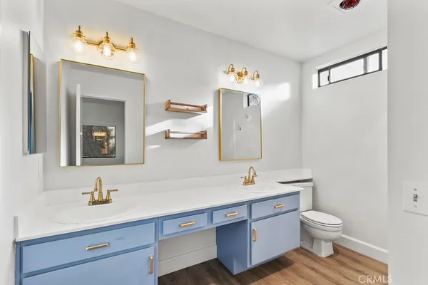 a bathroom with a sink mirror vanity and toilet