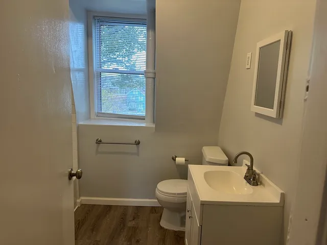 a bathroom with a toilet a sink and a window