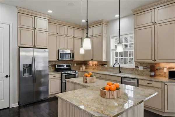 a kitchen with stainless steel appliances granite countertop a sink a refrigerator and a counter space