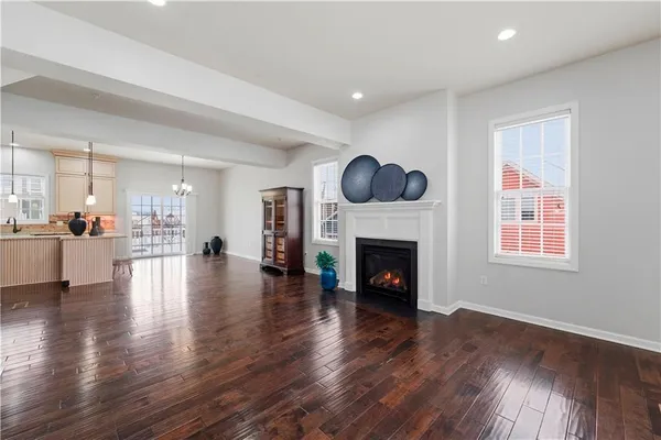a view of an empty room with wooden floor and a fireplace