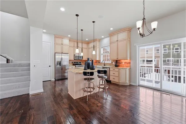 a kitchen with stainless steel appliances granite countertop wooden floors sink and cabinets