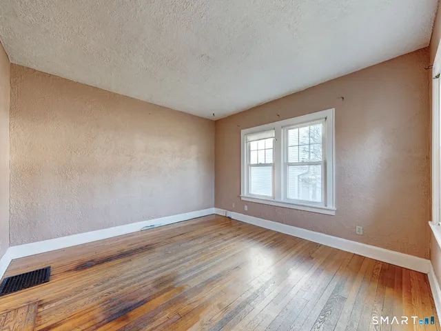 a view of an empty room with wooden floor