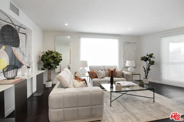 a living room with furniture potted plant and a window