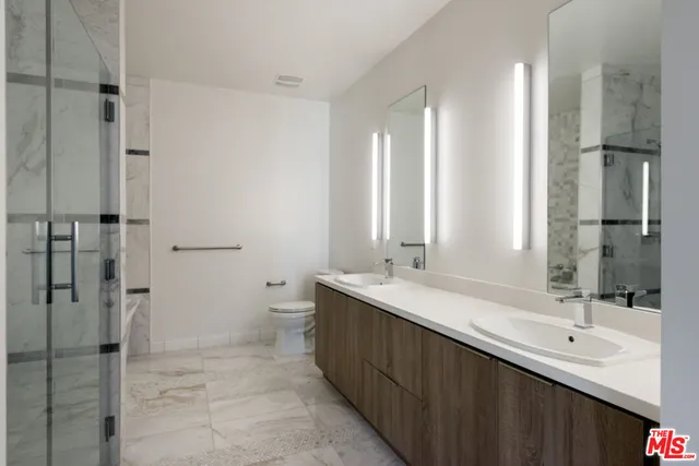 a bathroom with a double vanity sink mirror double and shower