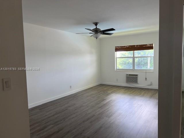 1350 East Sample Road, Unit 306 Pompano Beach, FL 33064 - Photo 5 of 13 an empty room with wooden floor chandelier fan and windows