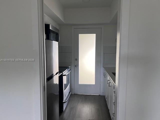 1350 East Sample Road, Unit 306 Pompano Beach, FL 33064 - Photo 10 of 13 a view of a hallway with wooden floor and staircase