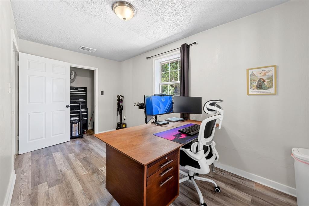 810 Edna Street Athens, TX 75751 - Photo 15 of 28 Light-filled room featuring wood-finish flooring, a window with dark drapery, a ceiling-mounted light fixture, and a closet with a paneled door