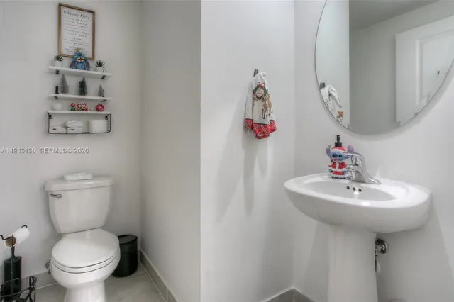 a bathroom with a sink toilet and a mirror