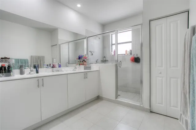a bathroom with a sink mirror and a shower