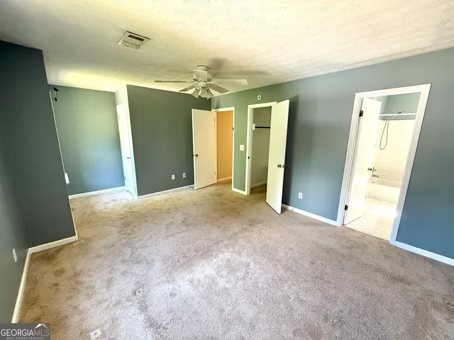 a view of a big room with closet and windows