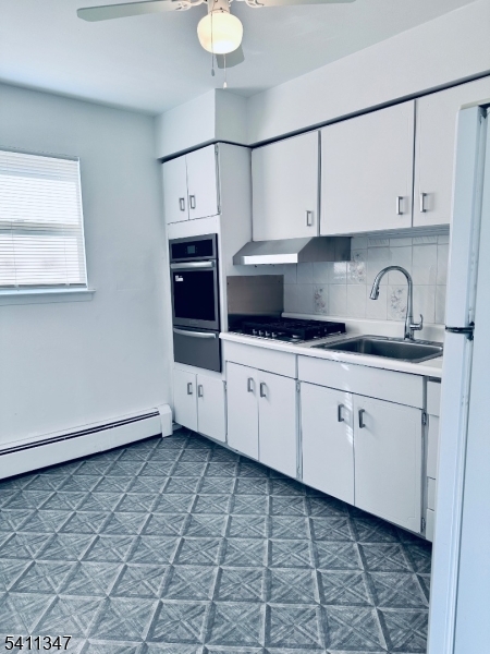 a kitchen with stainless steel appliances a sink a stove a microwave and cabinets