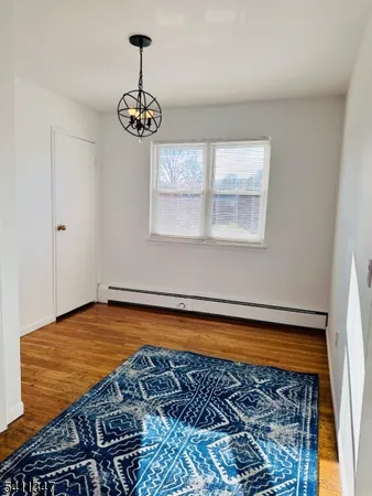 a view of a room with wooden floor chandelier and a window