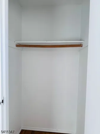 a view of a closet with wooden floor