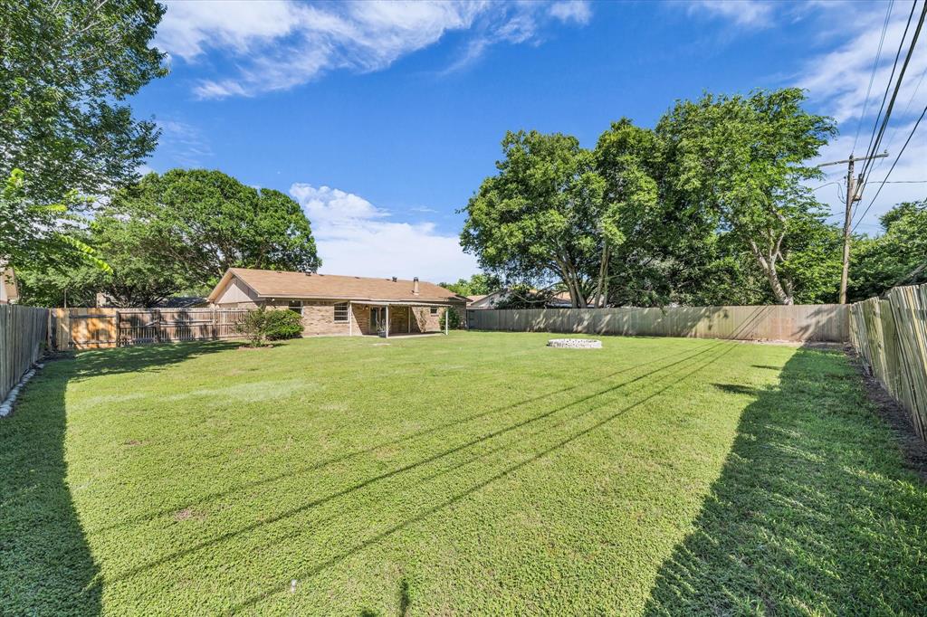 141 Travis Lane Hewitt, TX 76643 - Photo 26 of 31 Expansive backyard featuring a manicured lawn, full perimeter wood fencing, and mature trees