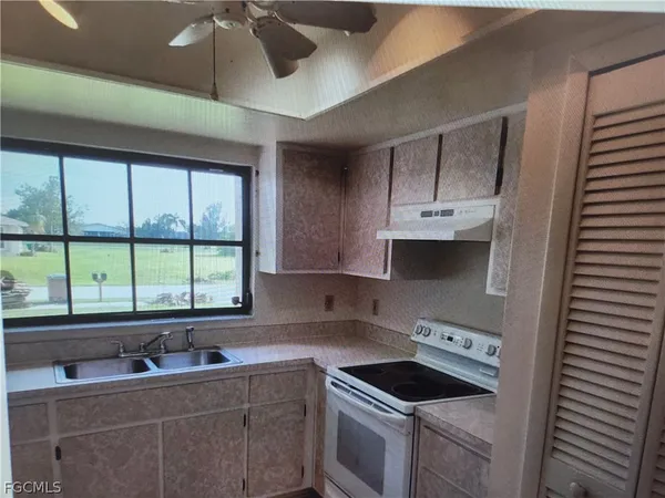 a kitchen with a sink stove and cabinets
