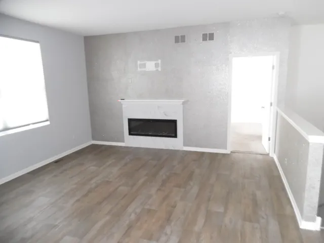 a view of empty room with wooden floor and fireplace