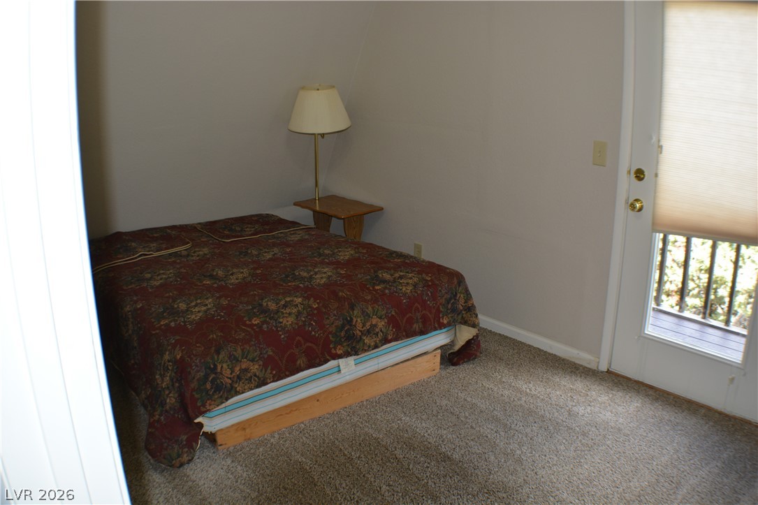 1321 Trout Canyon Road Las Vegas, NV 89124 - Photo 30 of 50 A cozy bedroom features soft carpeting and convenient balcony access.