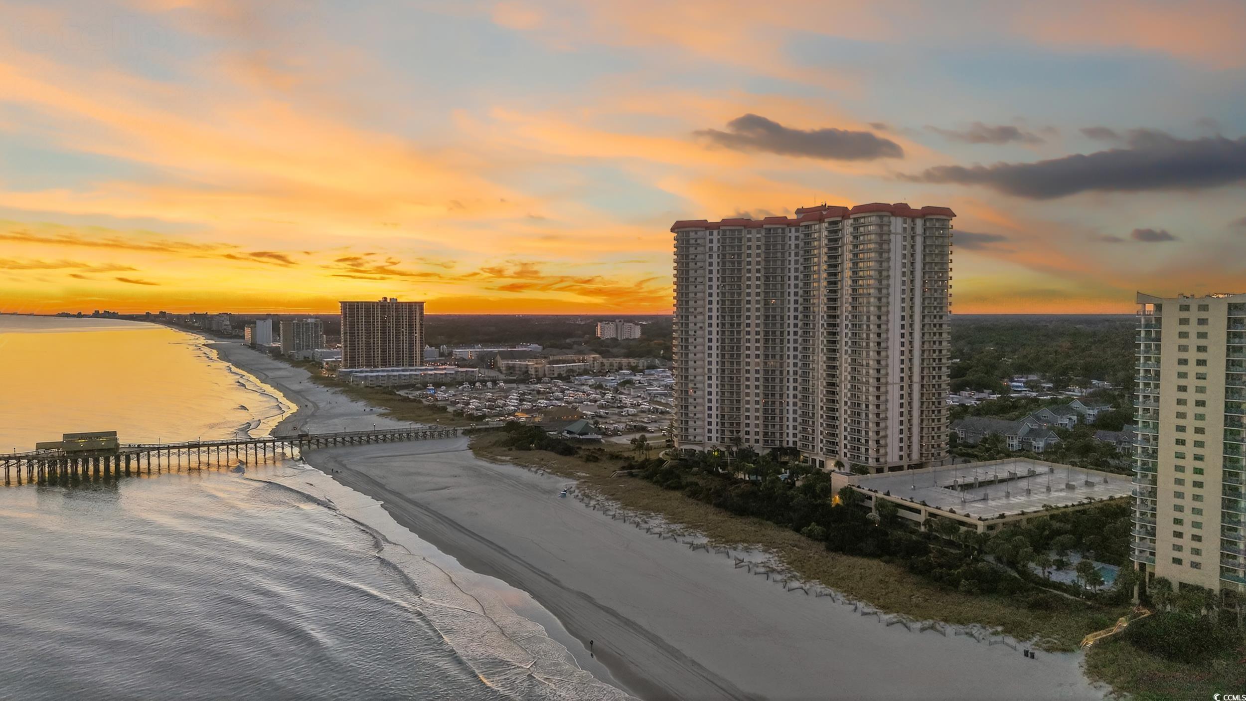Aerial view at dusk of view of water and beach and a view of city