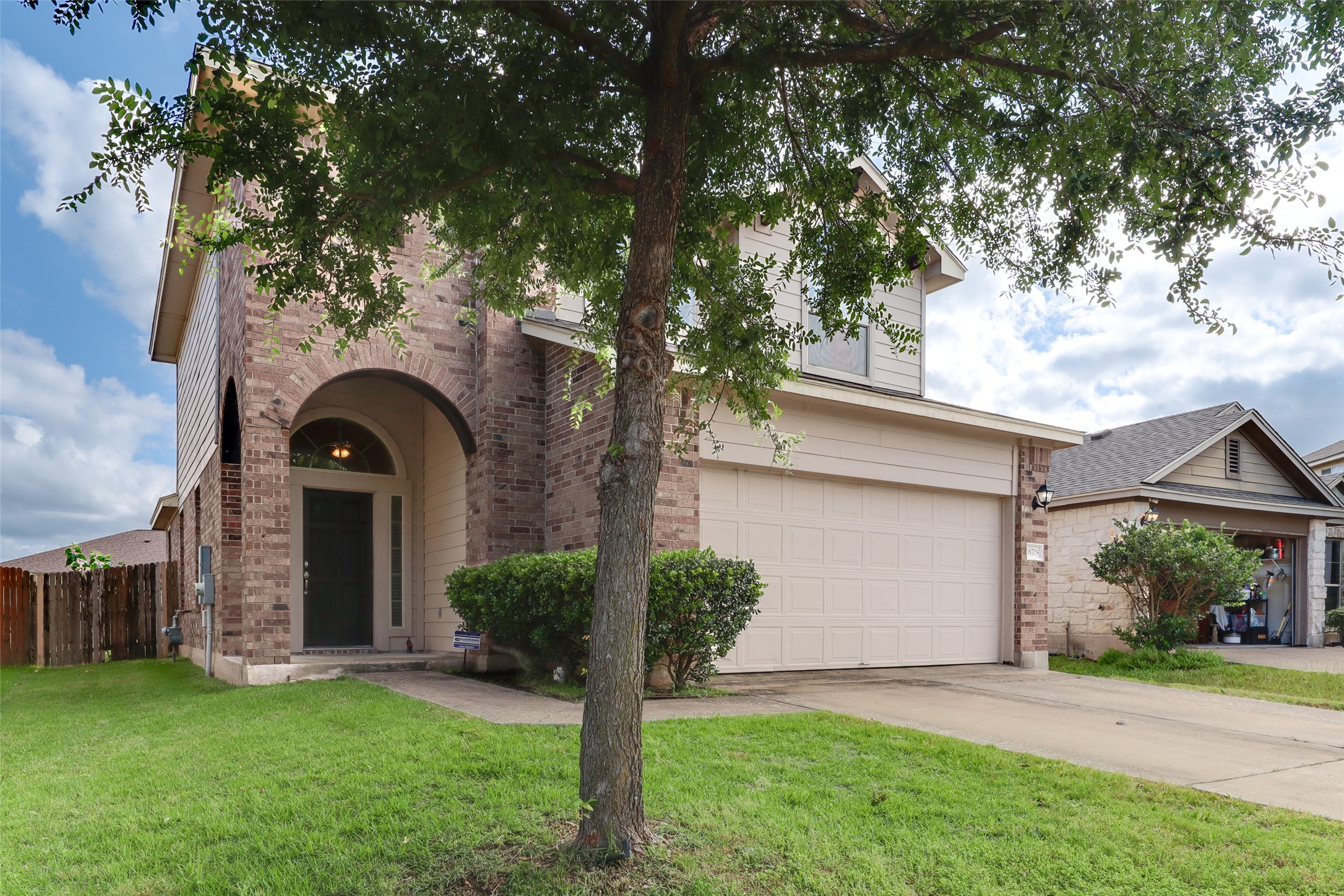 18705 Moreto Loop Pflugerville, TX 78660 - Photo 2 of 21 A classic brick and siding residence with a welcoming arched entryway and an attached garage.