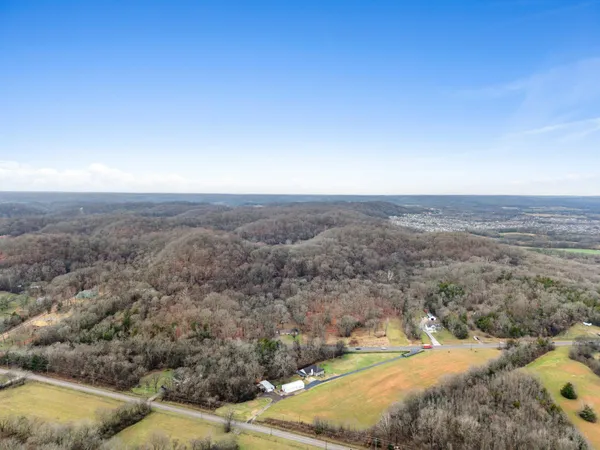 an aerial view of house with yard and mountain view in back