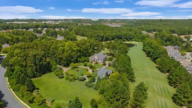 a aerial view of a house with a yard and large trees