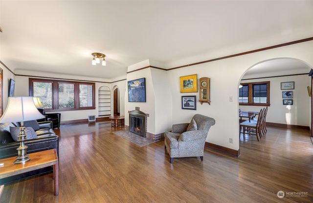 a living room with fireplace furniture and wooden floor