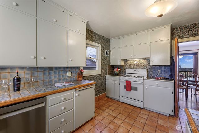 a kitchen with white cabinets and white appliances