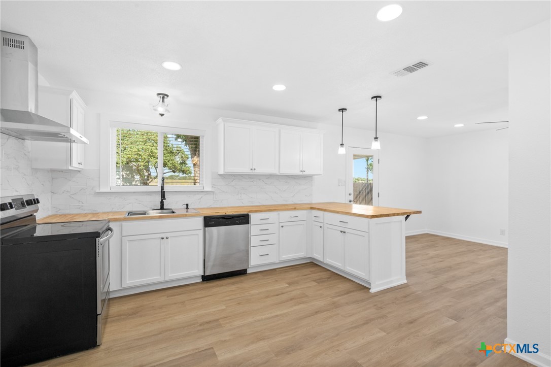 208 Eleanor Street Victoria, TX 77904 - Photo 18 of 40 a large kitchen with a lot of counter space and wooden floor