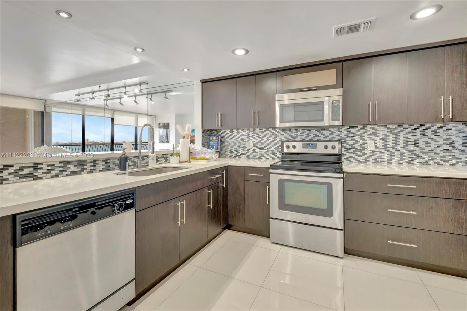 555 Northeast 15th Street, Unit 20B Miami, FL 33132 - Photo 6 of 33 a kitchen with stainless steel appliances granite countertop a sink stove and cabinets