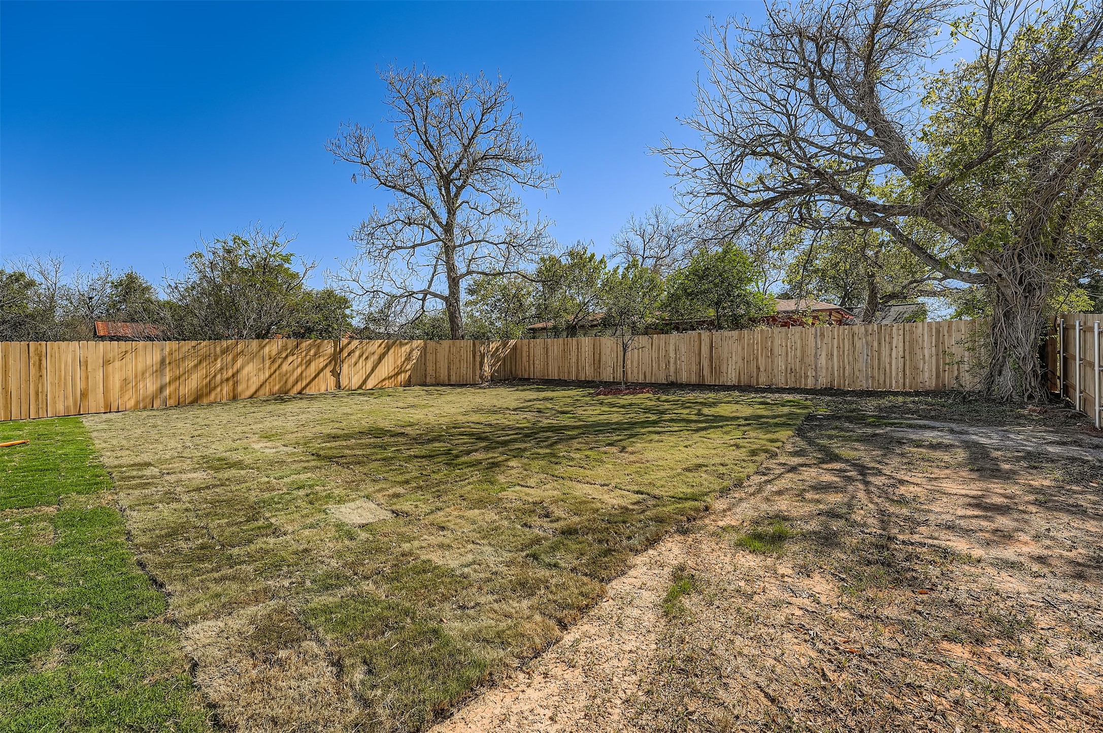 701 East 3rd Street Elgin, TX 78621 - Photo 31 of 35 Spacious fenced backyard with plenty of open green space, perfect for outdoor activities and entertaining