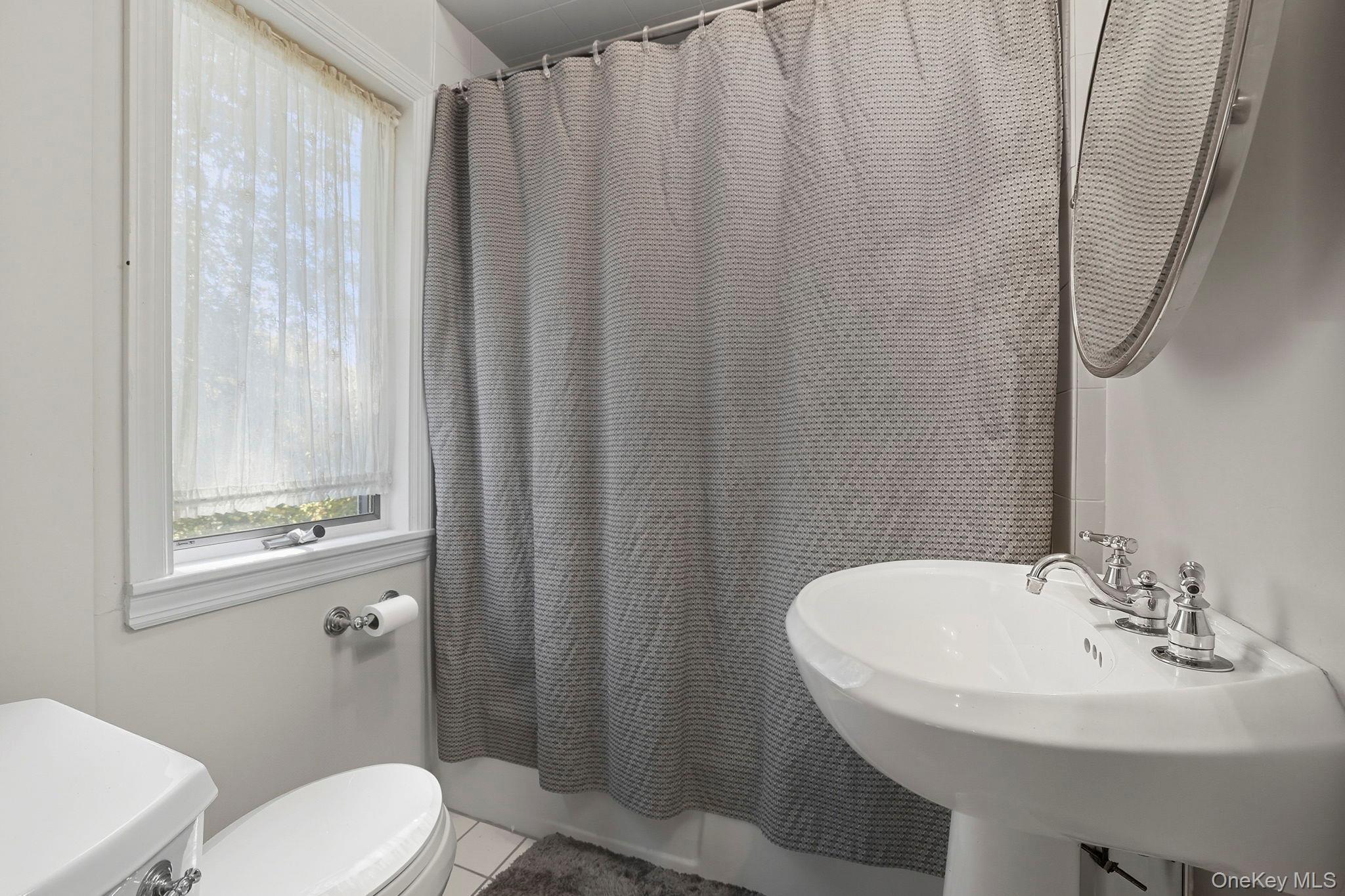122 Harriman Road Mount Kisco, NY 10549 - Photo 21 of 39 a bathroom with a sink a toilet and shower curtain