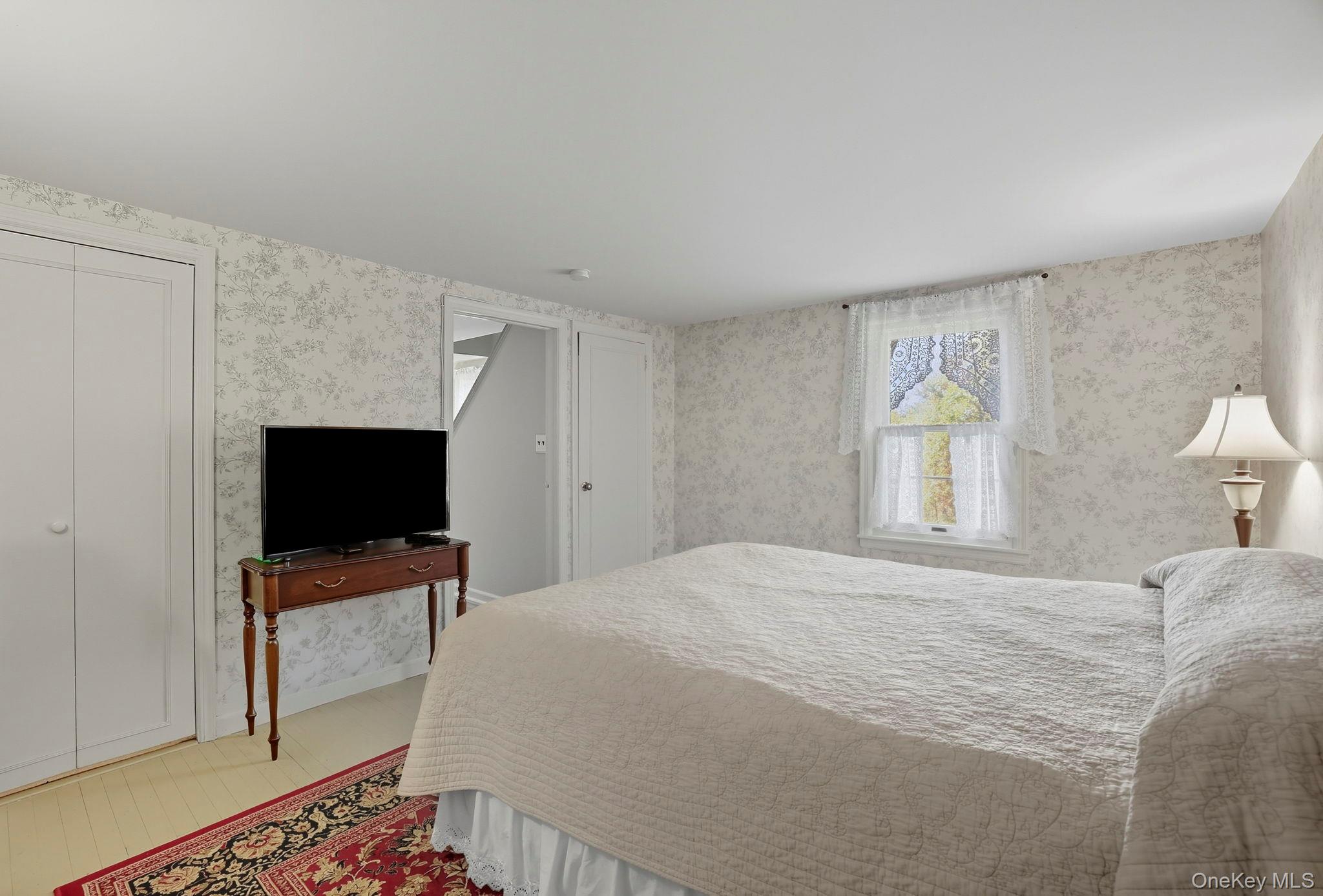 122 Harriman Road Mount Kisco, NY 10549 - Photo 23 of 39 a bedroom with a bed tv and a window