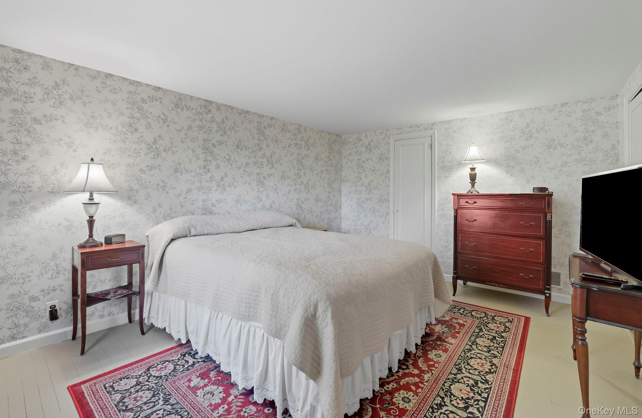 122 Harriman Road Mount Kisco, NY 10549 - Photo 24 of 39 a bedroom with a bed and a flat screen tv